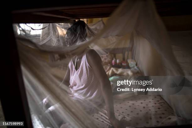 Joy, a trafficking survivor from Cameroon who used a pseudonym, sits with her two-week-old daughter in a private shelter in Lagos, Nigeria. She was...