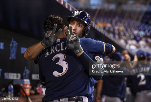 Ryan Braun of the Milwaukee Brewers gestures the number of Christian Yelich while celebrating with Orlando Arcia after hitting a two run home run in...