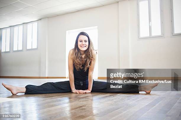 woman doing splits in dance studio - spagat stock-fotos und bilder