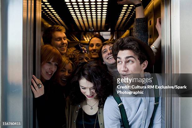 people crowding into elevator - estrujar fotografías e imágenes de stock