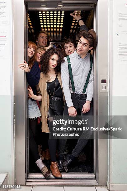 people crowding into elevator - crowded elevator stockfoto's en -beelden