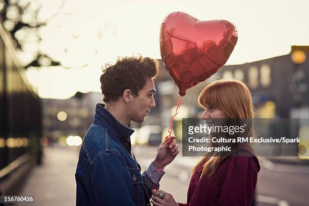 couple walking with heart-shaped balloon - バレンタインデー ストックフォトと画像