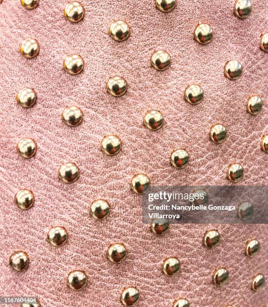 pink faux leather material with gold coloured metal studs. - bespickt stock-fotos und bilder