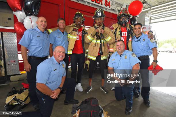 Danuel House Jr. #4, Gerald Green, and Gary Clark of the Houston Rockets pose for a photo with firefighters during a visit to Houston Police Station...