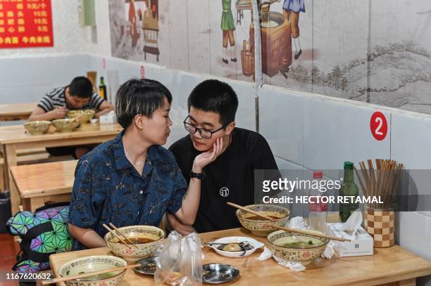 This photo taken on August 30, 2019 shows Trans Chorus member Fang Yuran with his girlfriend during lunch one day before the group's musical...
