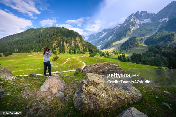young woman photographer taking photo of thajiwas park in kashmir, india - himachal pradesh stock pictures, royalty-free photos & images