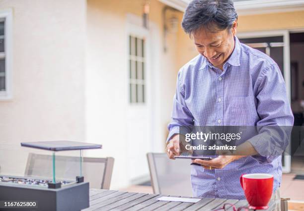 man depositing checks with smartphone - deposit slip stock pictures, royalty-free photos & images