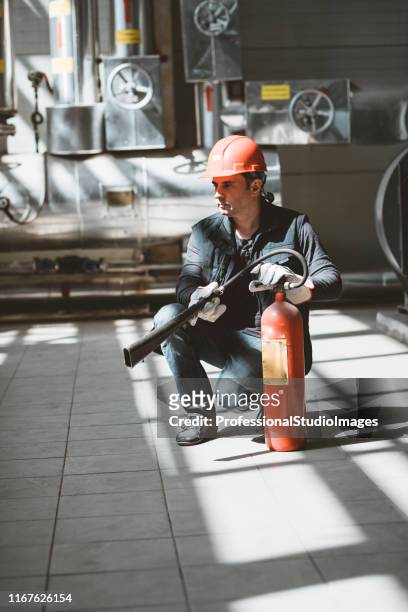 worker with fire extinguisher at the heat station - fire extinguisher inspection stock pictures, royalty-free photos & images