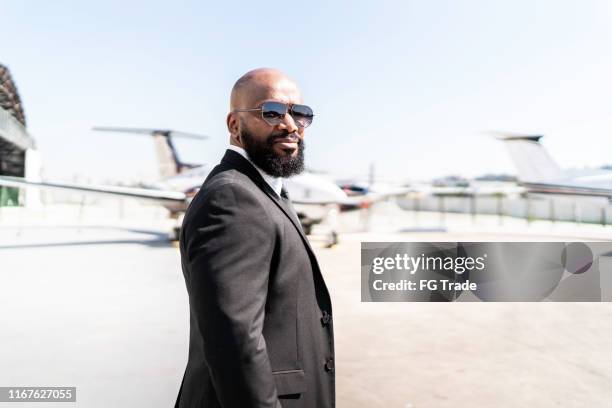 portrait of businessman standing in front of corporate jet - best sunglasses for bald men stock pictures, royalty-free photos & images