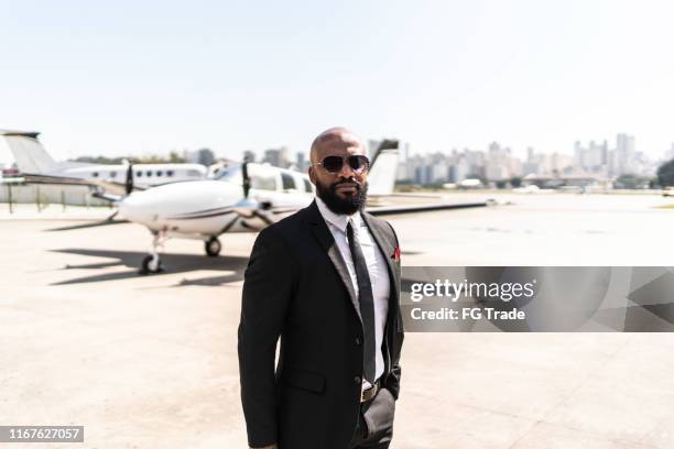 retrato del hombre de negocios frente al jet corporativo - best sunglasses for bald men fotografías e imágenes de stock