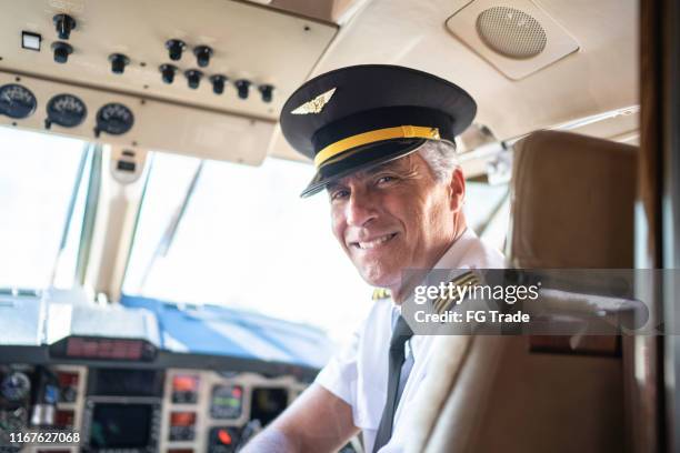 portrait of airplane pilot looking over shoulder in a private jet - airline pilot imagens e fotografias de stock