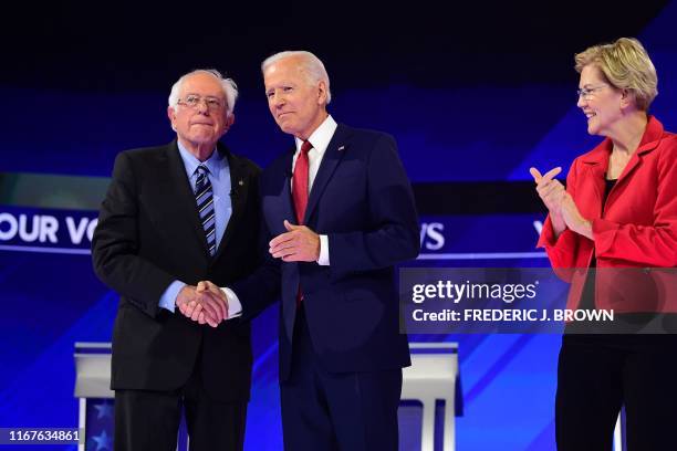 Democratic presidential hopeful Massachusetts Senator Elizabeth Warren looks on as former Vice President Joe Biden and Vermont Senator Bernie Sanders...
