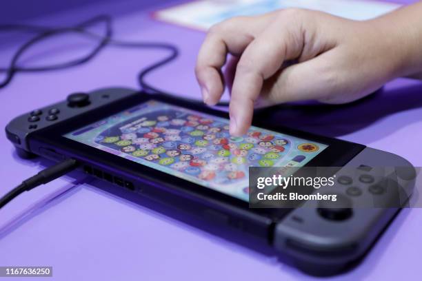 An attendant uses a Nintendo Co. Switch game console to demonstrate the Disney Tsum Tsum Festival video game in the Bandai Namco Entertainment Inc....