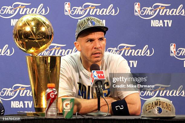 Jason Kidd of the Dallas Mavericks answers questions from the media as the Larry O'Brien Championship trophy sits on the table during a post game...