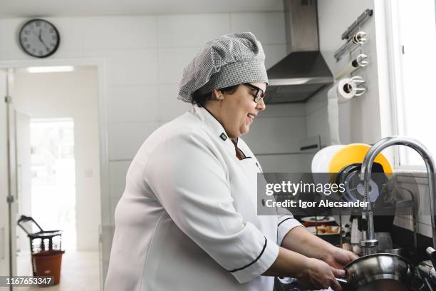 woman chef doing the dishes - washing dishes restaurant stock pictures, royalty-free photos & images