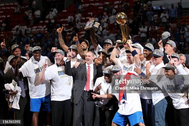 Jason Kidd of the Dallas Mavericks holds up the Larry O'Brien Championship trophy as he celebrates with his teammates, head coach Rick Carlisle and...