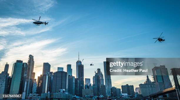 three police helicopters flying over the manhattan financial district in new york city at dusk - hélicoptère ville photos et images de collection
