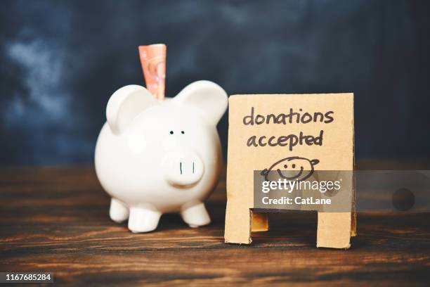 piggy bank with sandwich board reading donations accepted - donate money stock pictures, royalty-free photos & images