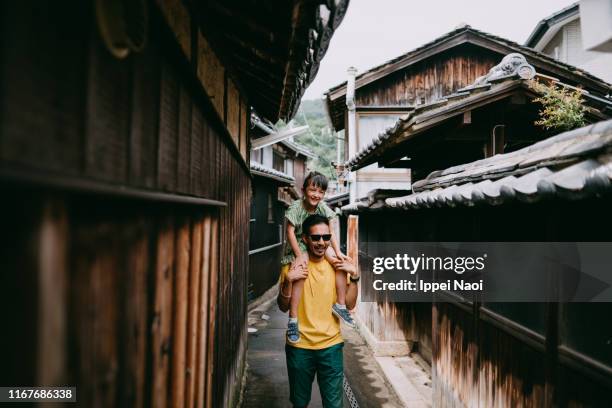 father carrying preschool girl on shoulders in old japanese village - seto inland sea stock pictures, royalty-free photos & images