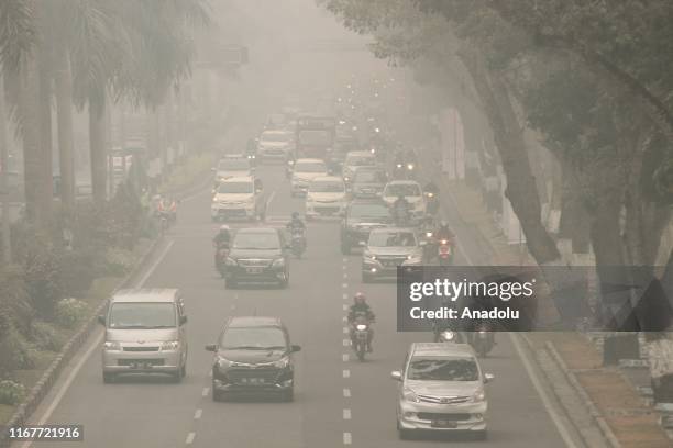 Vehicles are seen passing on highway in thick haze that surrounds Pekanbaru City, Riau Province, Indonesia on September 13, 2019. According to the...