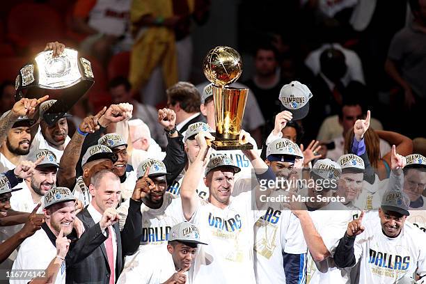 Jason Kidd of the Dallas Mavericks holds up the Larry O'Brien Championship trophy as he celebrates with his teammates, head coach Rick Carlisle and...