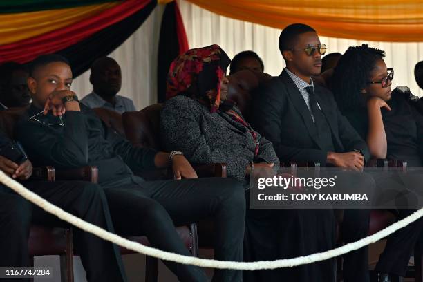 The children of Zimbabwe's former President, the late Robert Mugabe, Robert Junior , Chatunga and Bona sit in an official tribune at Rufaro stadium...