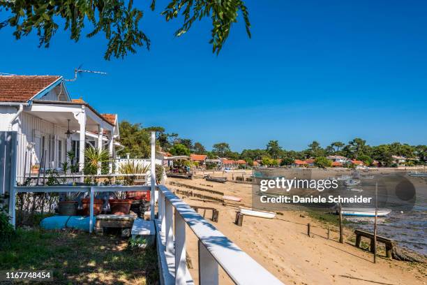 france, gironde, arcachon bay, cap-ferret, canon oyster village, houses along the beach and grounded boats at low tide - cap ferret stock pictures, royalty-free photos & images