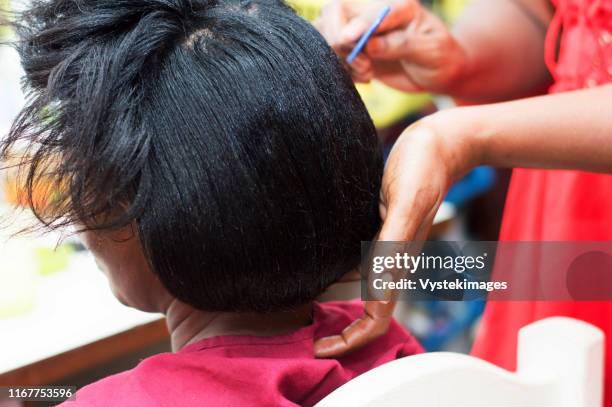 the hairdresser creates a model of hair on the head of her clent. - cheveux lisses photos et images de collection