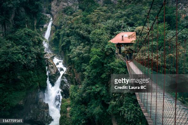 suspension bridge next to a waterfall in ecuador. - ecuador fotografías e imágenes de stock