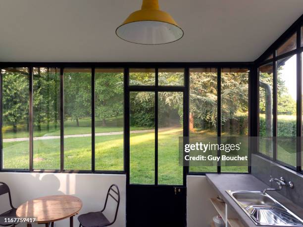 europe, france, bourgogne, epoisses, kitchen with large glass window overlooking the garden - bay window interior stock pictures, royalty-free photos & images