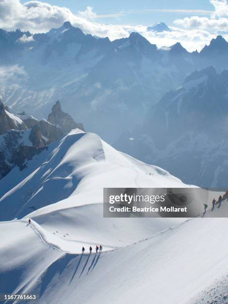 france, haute savoy, chamonix, mont blanc range, some alpinists are hiking on the snow edge of the aiguille du midi - aiguille de midi fotografías e imágenes de stock