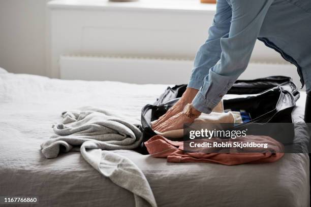 closeup of womans hands packing suitcase on bed - dänemark gemütlich stock-fotos und bilder