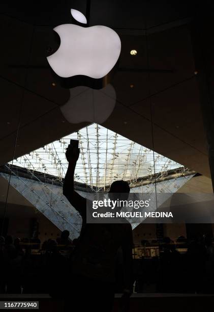 Customer from Netherlands, Maurice, who arrived at 4 a.m, holds his iPhone 4 in front of a mobile phone store at the Carrousel du Louvre shopping...