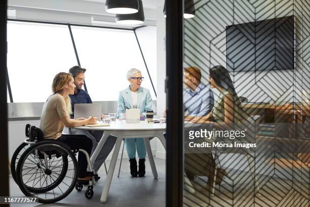 business people discussing in office meeting - wheelchair office stock pictures, royalty-free photos & images
