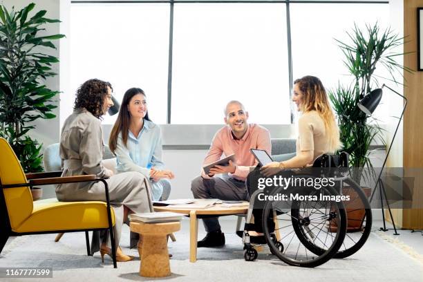 disabled professional with coworkers in meeting - junge frau im rollstuhl stock-fotos und bilder