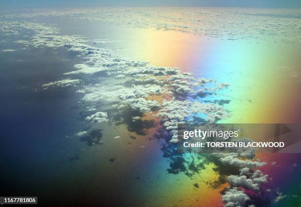 Scattered clouds over Bass Strait take on a surreal appearance when viewed from a tinted aircraft window through a circular polariser, 11 January...