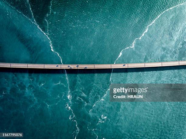 driving on a bridge over deep blue water - bridge stock pictures, royalty-free photos & images