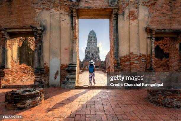 tourist journey asia thailand temple concept. women tourists and backpacks are walking. see wat ratchaburana in ayutthaya, thailand. ancient ruins in ayutthaya province is a world heritage site and is a historical tourist attraction. - ayuthaya stock pictures, royalty-free photos & images
