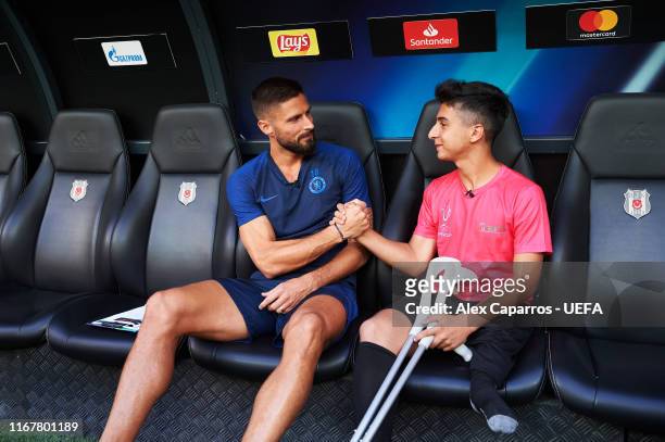 Olivier Giroud of Chelsea FC interviews a young amputee football player and UEFA Foundation guest before a training session ahead of UEFA Super Cup...
