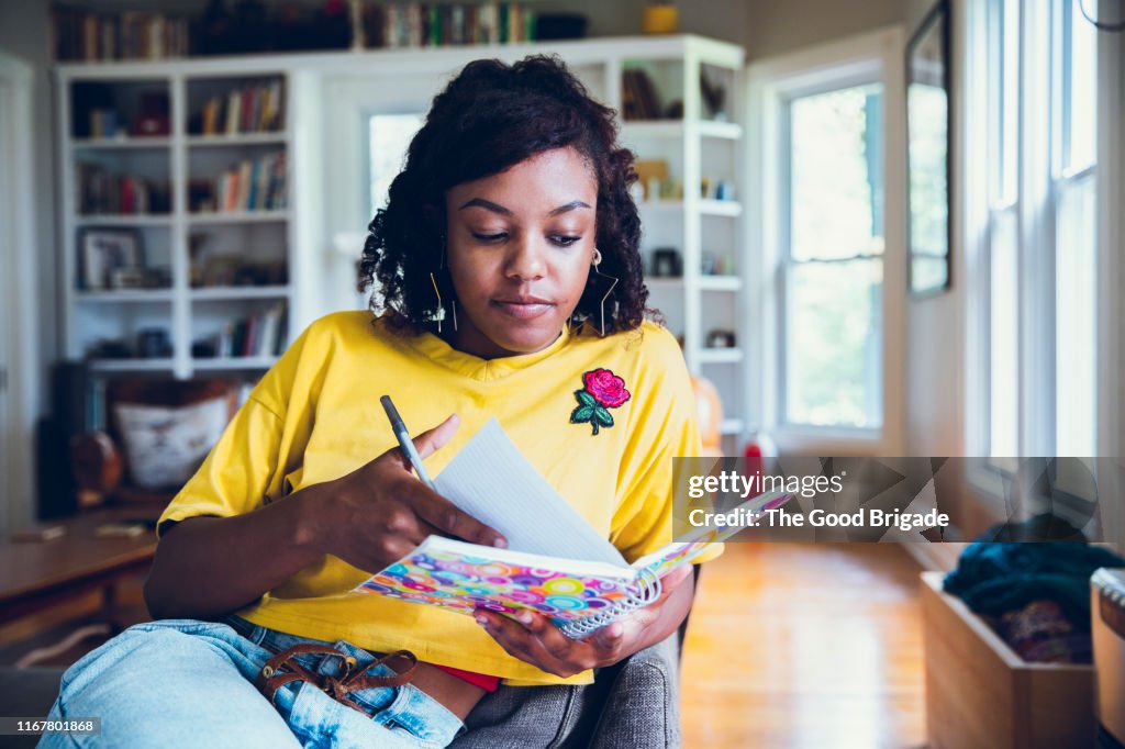 Young woman writing in notebook