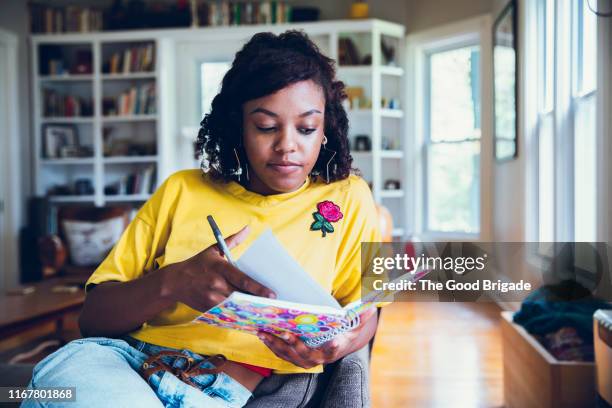 young woman writing in notebook - diary imagens e fotografias de stock