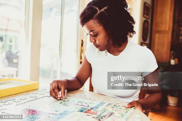 Young woman doing a puzzle at home