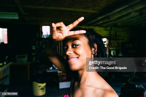 young woman making peace sign - victory sign stock-fotos und bilder