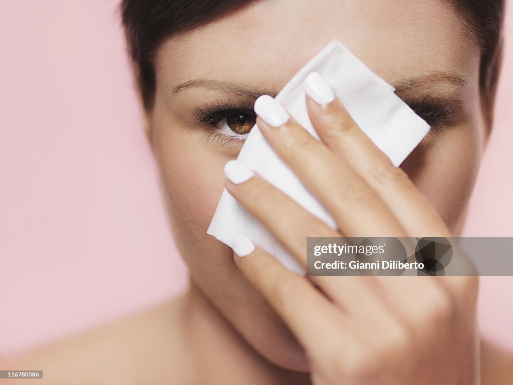 A woman peeking from behind a tissue
