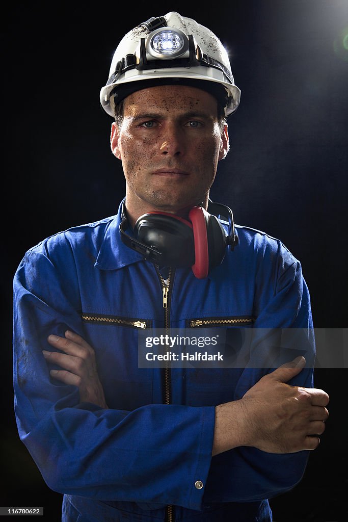 A coal miner with his arms crossed, portrait, waist up