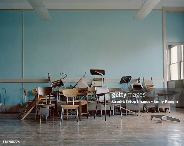 old, broken chairs in an abandoned school - abandonar fotografías e imágenes de stock