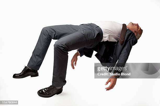 a sleeping businessman in mid-air, studio shot - levitation stock-fotos und bilder