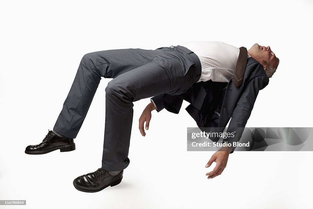 A sleeping businessman in mid-air, studio shot