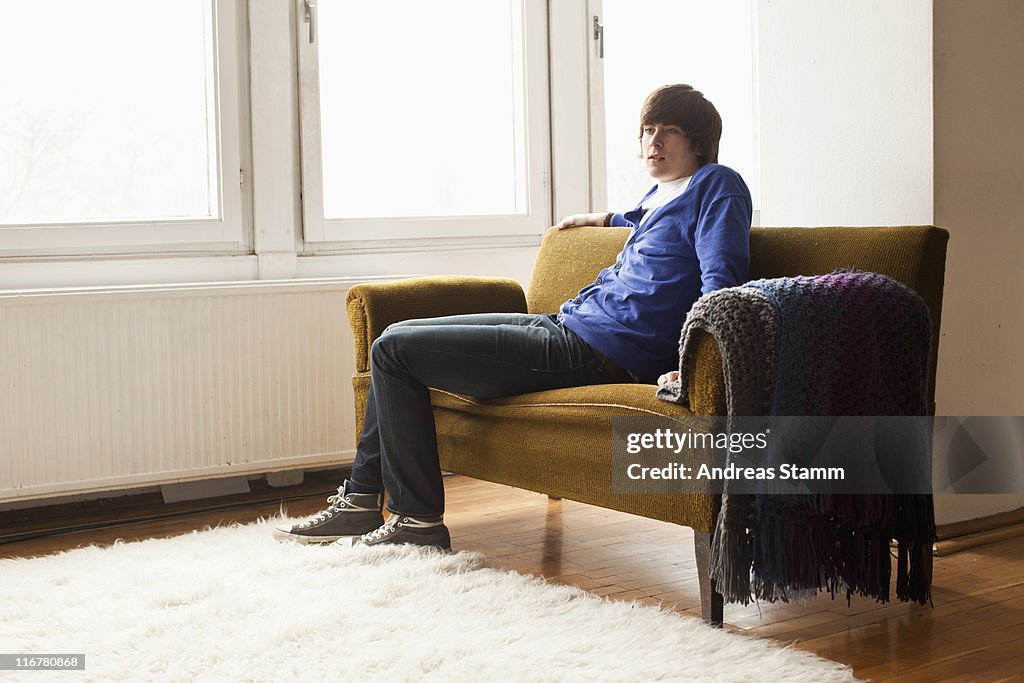 A teenage boy sitting on a couch