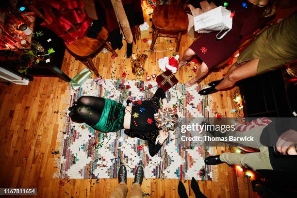 woman lying on floor covered in confetti with large bow over face during holiday party with friends - unterer teil stock-fotos und bilder